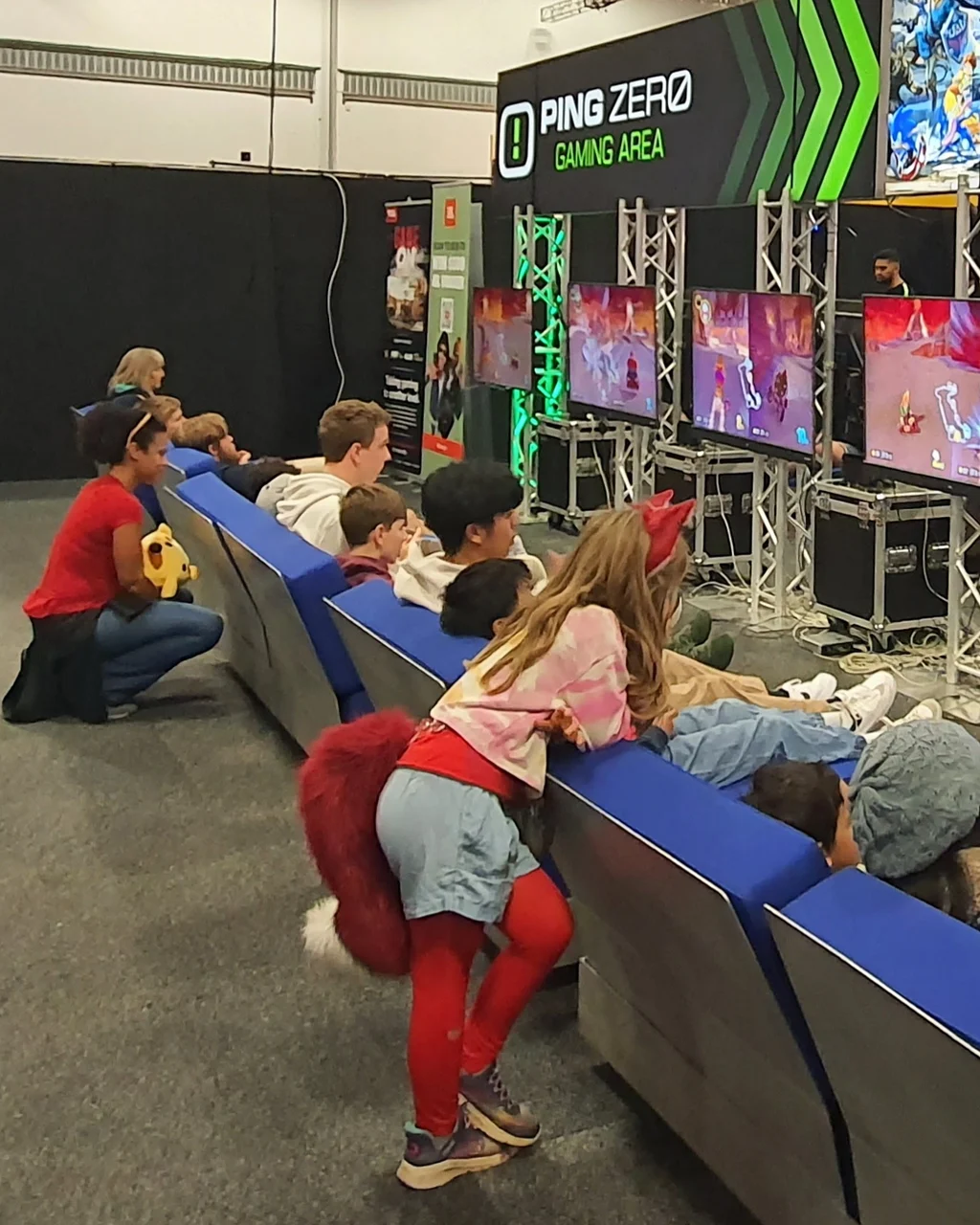 Kids racing Mario Kart on a row of screens in the Ping Zero Gaming Area