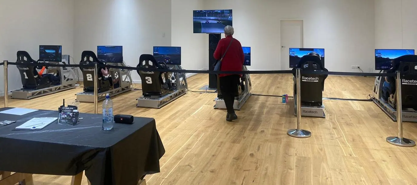 Six Ping Zero Racetech sim rigs set up in a row at an event, September 2023