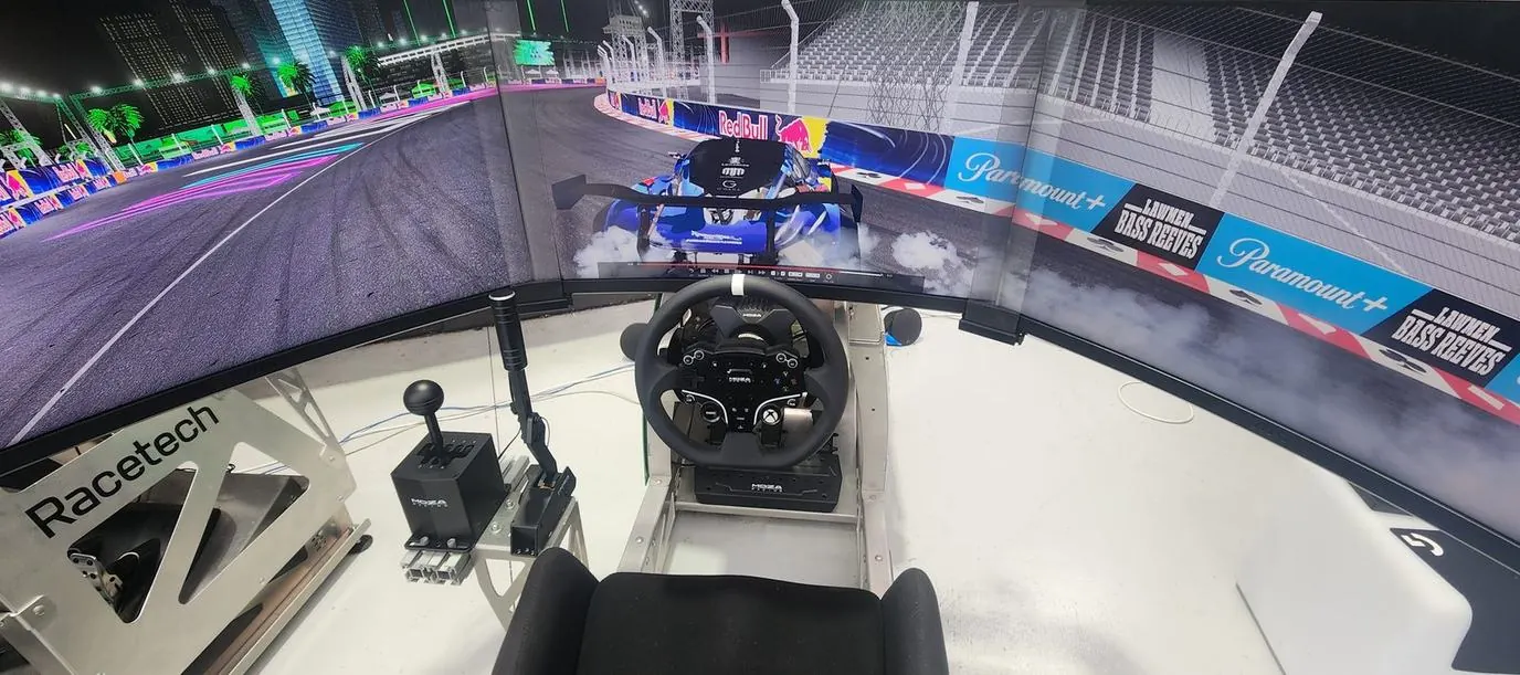 Racetech sim rig with triple screens and an H-pattern shifter, running a drift car